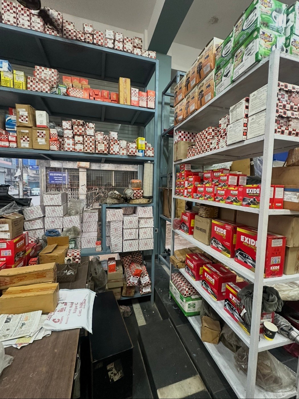 Inside Kuldeep Motors: shelves stocked with parts and batteries